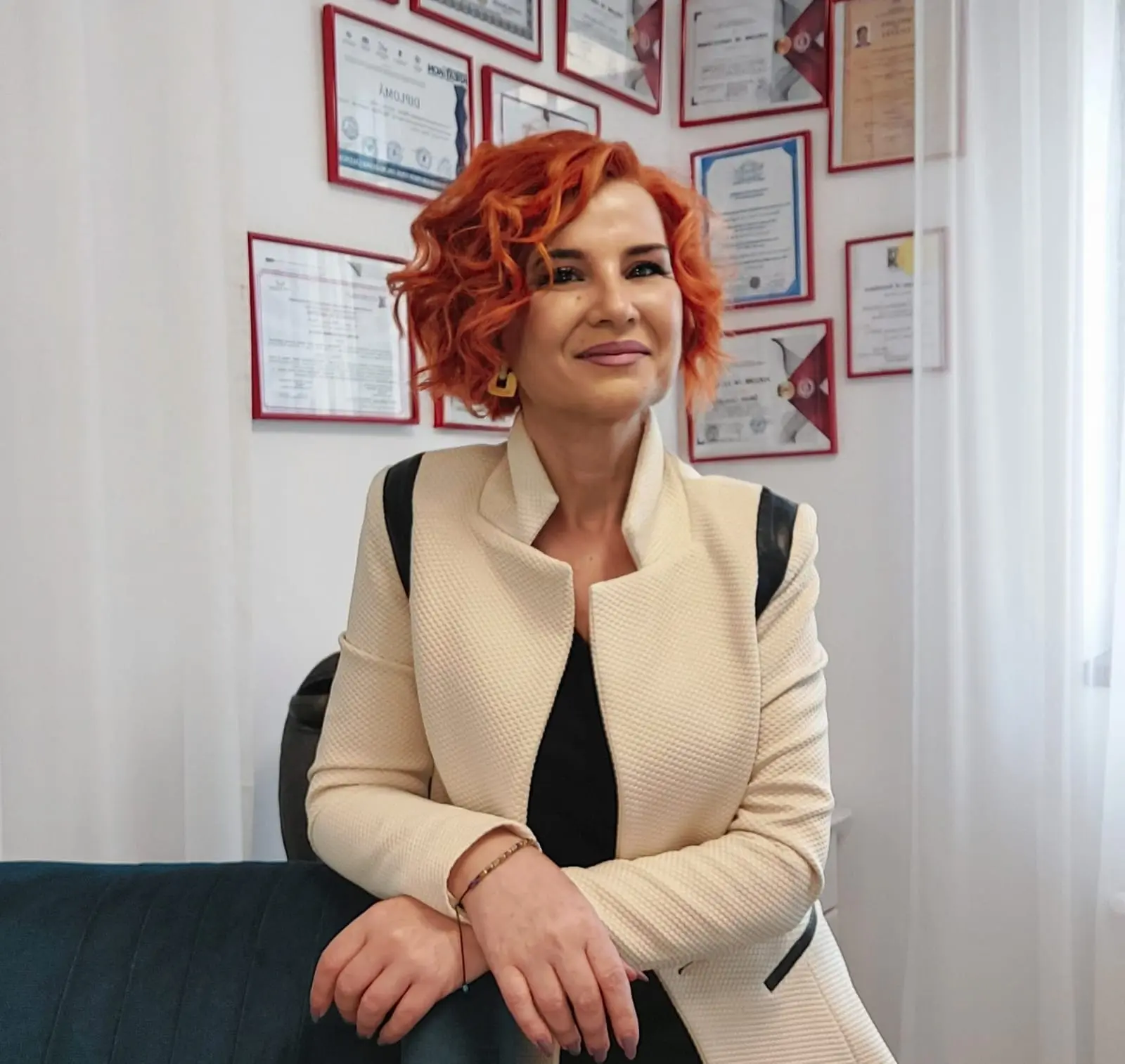 Psiholog Carmen Gavrilescu zâmbește în cabinetul său, înconjurată de diplome – empatie, profesionalism, experiență.